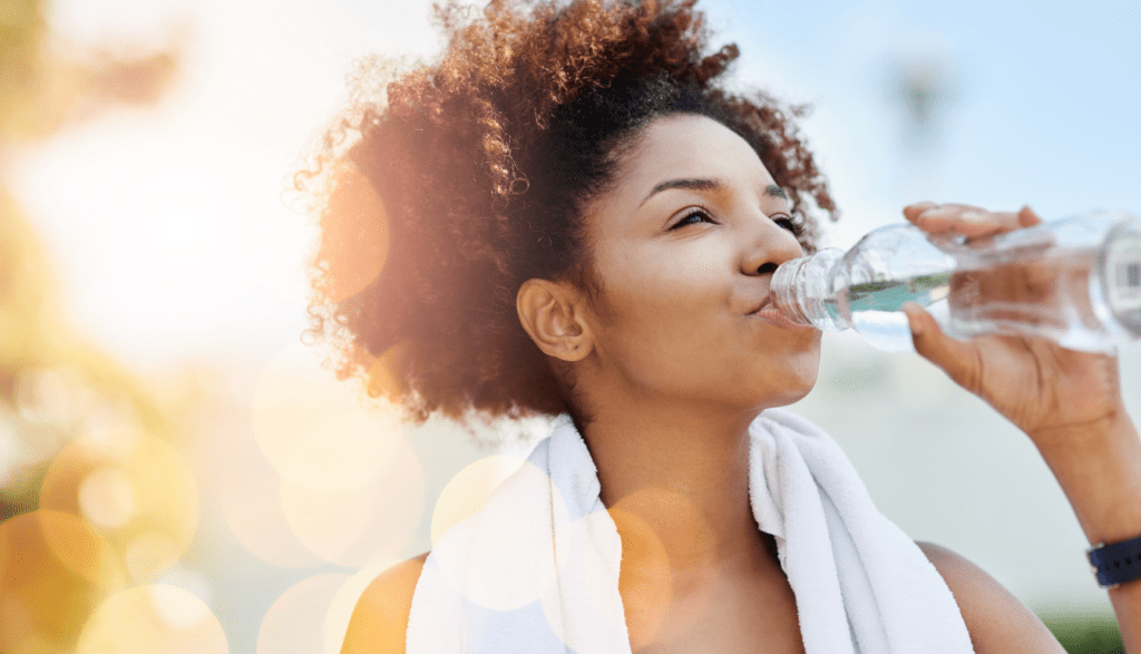 A woman drinking water after running
